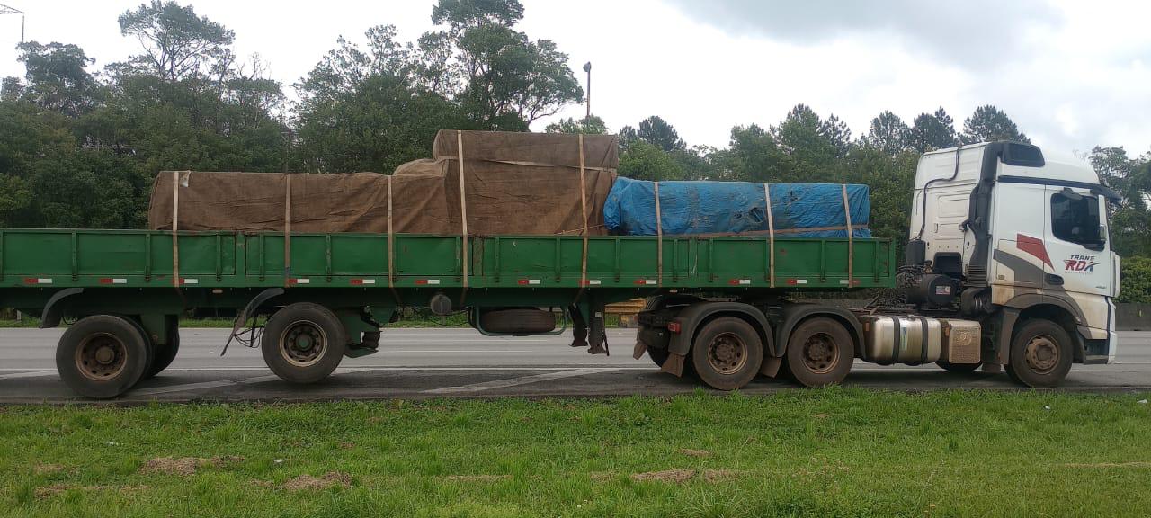 Caminhão RDA com carga geral protegida em carroceria aberta
